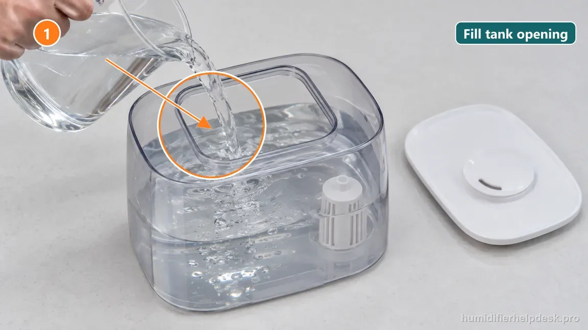 Clean water is poured into the removable translucent humidifier tank while it is off the base.