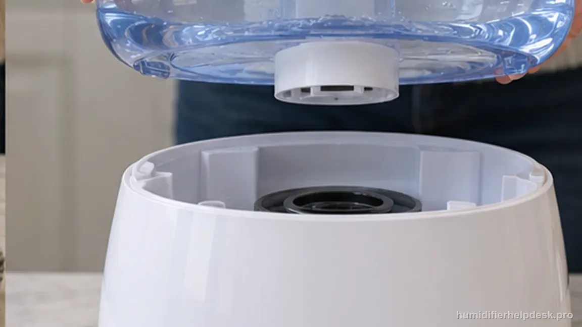 A filled translucent blue tank is lowered squarely onto the white humidifier base so its bottom valve aligns with the reservoir.