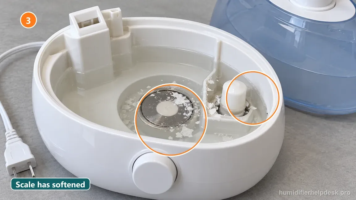 Mineral flakes have loosened in the vinegar around the humidifier basin and ultrasonic disc.